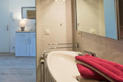ein Badezimmer mit einer weißen Badewanne und einem roten Handtuch in der Unterkunft Hafenkante in Husum
