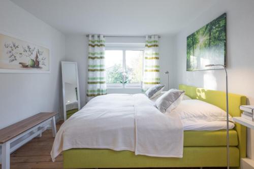 een slaapkamer met een groot bed en een raam bij Moenkevilla in Husum