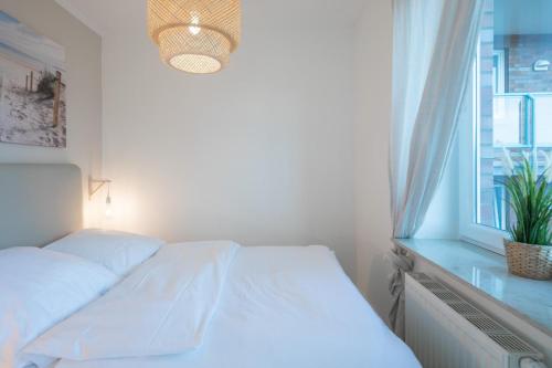 a white bed in a room with a window at Waterkant in Husum