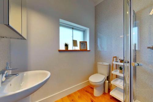 Un baño con lavabo, inodoro y ventana. en Finest Retreats - Peak Dale Apartment, en Matlock