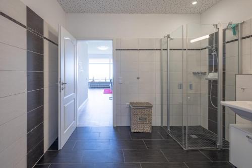 a bathroom with a walk in shower and a glass door at Carpe Diem in Husum