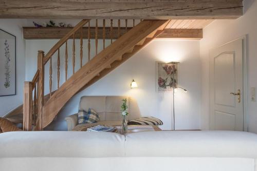 a living room with a staircase and a chair at Ferienhaus Geest auf Föhr in Borgsum