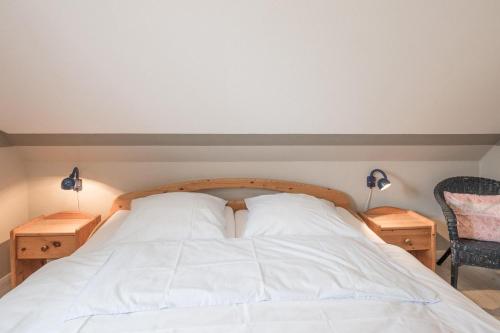 a bedroom with a bed with two night stands and two lamps at Ferienhaus Marsch auf Föhr in Borgsum