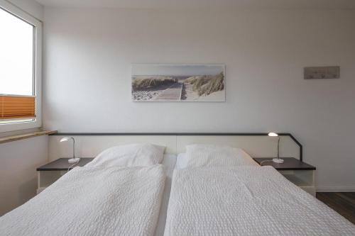 ヴィーク・アウフ・フェールにあるStrandperleのベッドルーム1室(白いシーツと写真付)