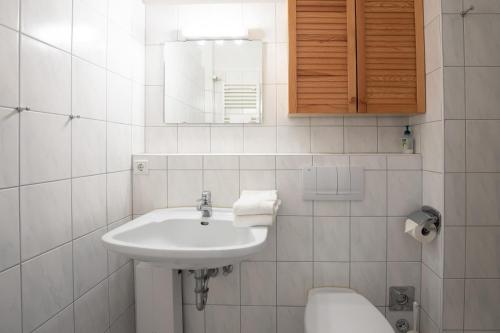 La salle de bains blanche est pourvue d'un lavabo et de toilettes. dans l'établissement Strandperle, à Wyk auf Föhr