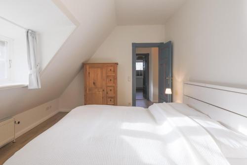ein Schlafzimmer mit einem weißen Bett und einem Fenster in der Unterkunft Reethus Schobüll in Husum