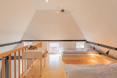 a attic bedroom with a bed and a desk at Ferienhaus Broderswarft in Dagebüll