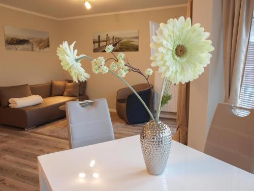 Un jarrón con flores sobre una mesa en una sala de estar. en Apartment Godewind, en Dagebüll