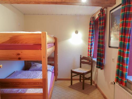 HumptrupにあるFerienwohnung Diekのベッドルーム1室(二段ベッド2台、椅子付)