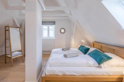ein Schlafzimmer mit einem weißen Bett mit blauen Kissen in der Unterkunft Strandläufer in Husum