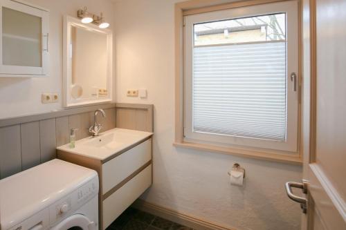ein Badezimmer mit einem Waschbecken und einer Waschmaschine in der Unterkunft Ferienhaus vor Rügen in Sundhagen-Niederhof