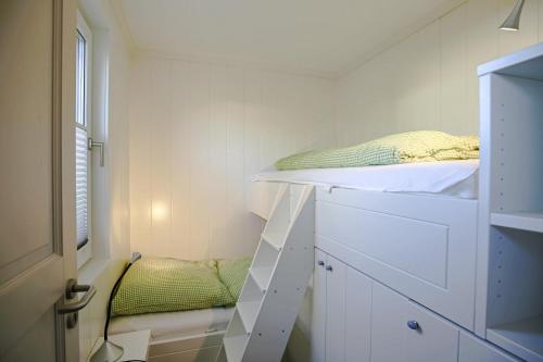 ein kleines Zimmer mit einem Etagenbett und einem Fenster in der Unterkunft Ferienhaus vor Rügen in Sundhagen-Niederhof