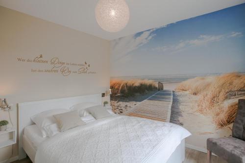 フーズムにあるIn der Schlossstraßeの白いベッドとビーチの絵画が備わるベッドルーム1室