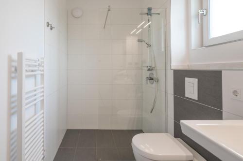a white bathroom with a toilet and a sink at Ankerzeit in Husum