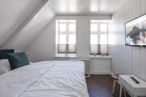 フーズムにあるApartmenthaus Theodor Storm - Unter Sternenの白いベッドルーム(ベッド1台、テーブル、窓付)