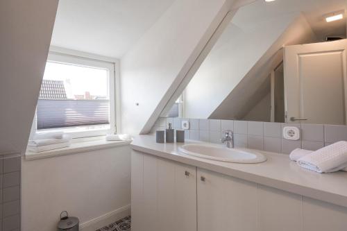 フーズムにあるApartmenthaus Theodor Storm - Unter Sternenの洗面台と窓のある白いバスルーム