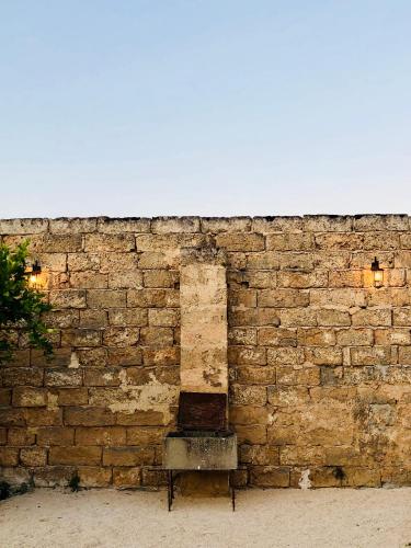 ガラトーネにあるMasseria Salentoの煉瓦の壁前に座るベンチ