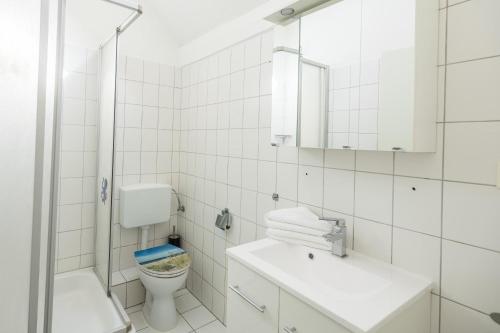フーズムにあるAnkerperleの白いバスルーム(トイレ、シンク付)