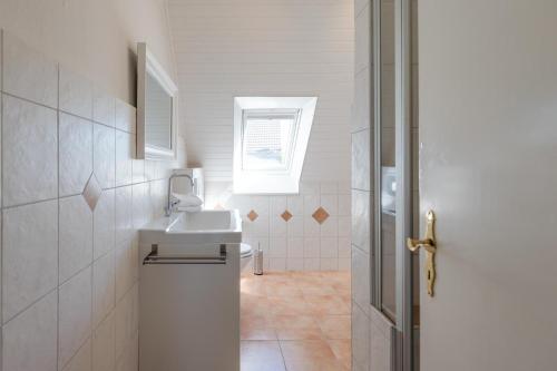 フーズムにあるDeichblickのバスルーム(洗面台、トイレ付)、窓が備わります。