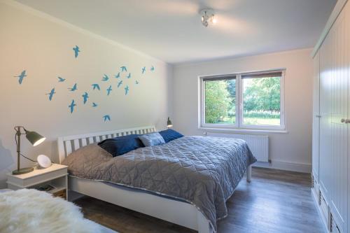 ein Schlafzimmer mit einem Bett mit Vögeln an der Wand in der Unterkunft Villa Lütt-KEINE MONTEURE- in Husum