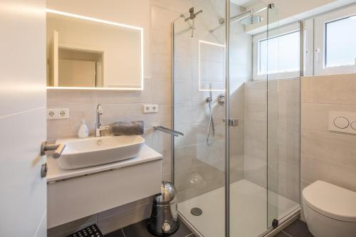 ein Bad mit einem Waschbecken und einer Dusche in der Unterkunft Villa Lütt-KEINE MONTEURE- in Husum
