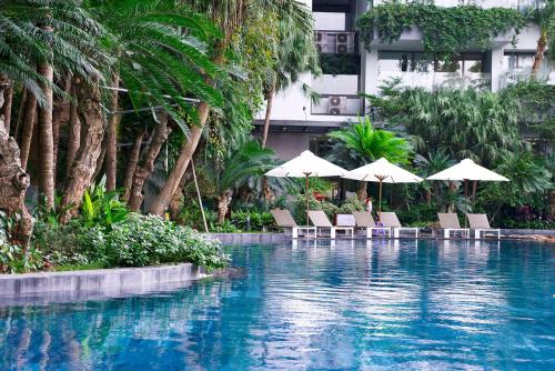 a swimming pool with chairs and umbrellas next to a building at Flamingo Resort Dai Lai in Ngọc Quang