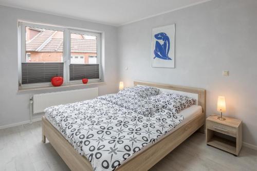 a bedroom with a bed with a black and white comforter at Storm's Nest in Husum