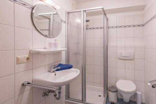 a white bathroom with a sink and a shower at Storm's Nest in Husum