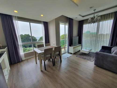 a living room with a table and chairs and a couch at The Exclusive @WON Beach Suite & Toproof Pool in Ban Bang Saen (1)