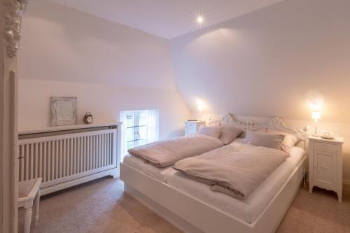 Lille Weiss-KEINE MONTEURE- في Drelsdorf: سرير أبيض كبير في غرفة بها مصباحين