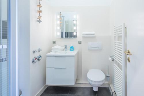 bagno bianco con servizi igienici e lavandino di Hafenblick a Husum