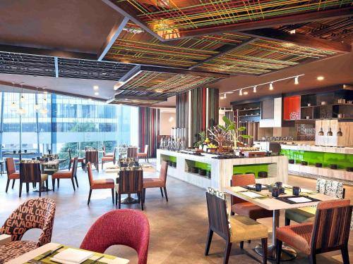 a restaurant with tables and chairs and a bar at Novotel Hanoi Thai Ha in Hanoi