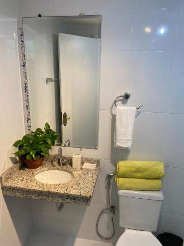 a bathroom with a sink and a toilet and a mirror at Vila Noel Premium in Penedo