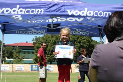 a girl is holding up a sign under a blue canopy at Karoopark Guest House in Graaff-Reinet