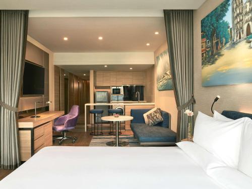 a hotel room with a bed and a kitchen at Novotel Hanoi Thai Ha in Hanoi