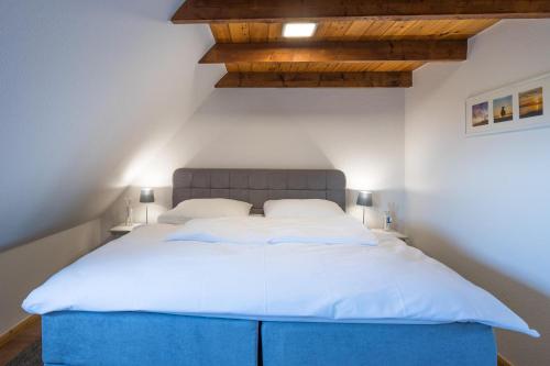 a bedroom with a large bed with a blue headboard at Hamburger Hallig in Bordelum