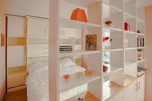 Cette chambre dispose d'étagères blanches et d'un lit. dans l'établissement Ferienhaus Bobby, à Stahlbrode
