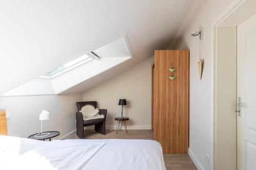 1 dormitorio con cama, silla y tragaluz en Alte Wassermuehle Hollebek, en Bredstedt