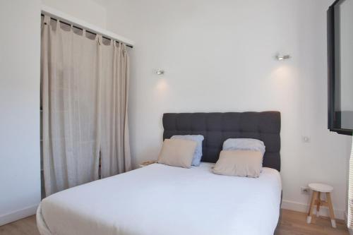 sypialnia z dużym białym łóżkiem z 2 poduszkami w obiekcie Casa Sol location de vacances indépendante à Calvi moins de 2km plage w Calvi