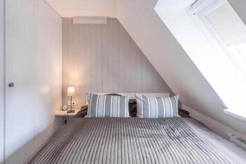 Schlafzimmer im Dachgeschoss mit einem Bett mit zwei Kissen in der Unterkunft Hannes Kapitänshaus in Husum