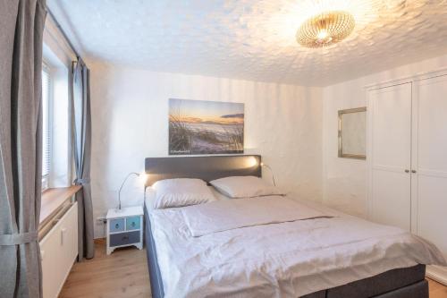 ein Schlafzimmer mit einem Bett und einer Decke in der Unterkunft Lodge in Westerland - Beachtime in Westerland