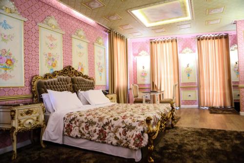 a bedroom with a bed and a pink wall at Golden Ring Resort in Tirana