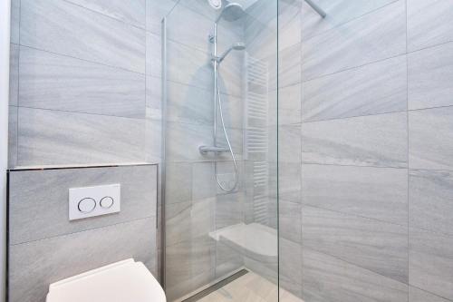 uma casa de banho com uma cabina de duche em vidro e um WC. em Appartement 718 em Timmendorfer Strand