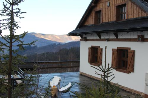 a house with a balcony with a view of the mountains at Chata Marguška - U Fera in Oščadnica
