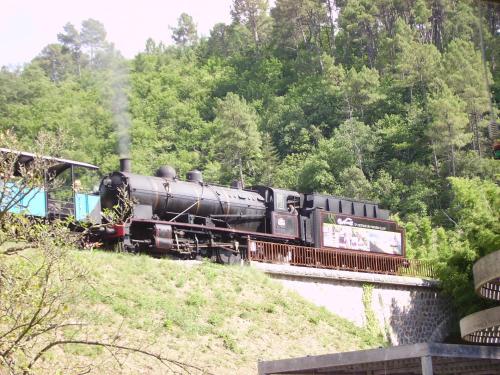 a black train is traveling down a bridge at Ibis Budget Saint Christol Les Alès in Saint-Christol-lès-Alès