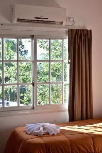 a bedroom with a bed and a large window at Alamo Hotel in Villa Carlos Paz