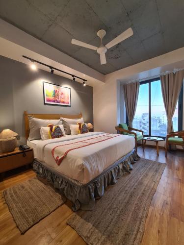 a bedroom with a large bed with a ceiling fan at Hotel Nova Boutique in Rajkot