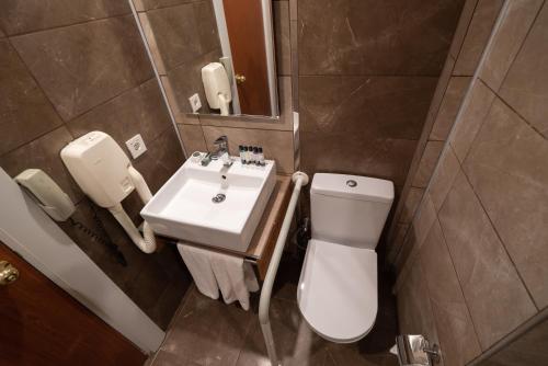 a bathroom with a white toilet and a sink at The Green Park Diyarbakir in Diyarbakır