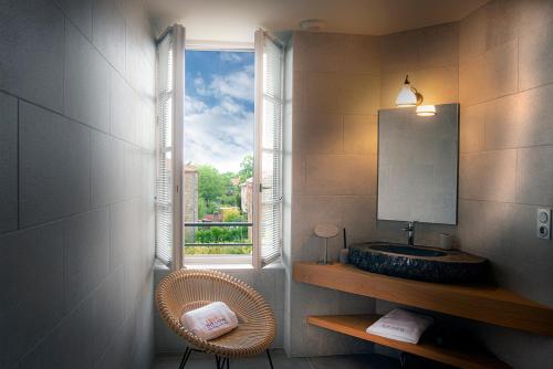 a bathroom with a sink and a window with a mirror at The view of Montpeyroux in Montpeyroux