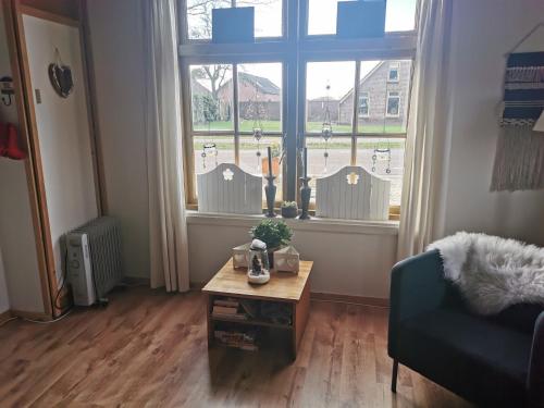a living room with a table in front of a window at B&B In De Backerije 2 in Zuidwolde